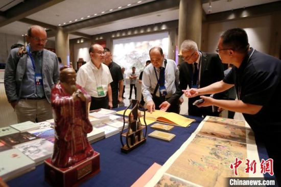 　　中外嘉宾在会场内翻阅中国典籍。梁犇 摄